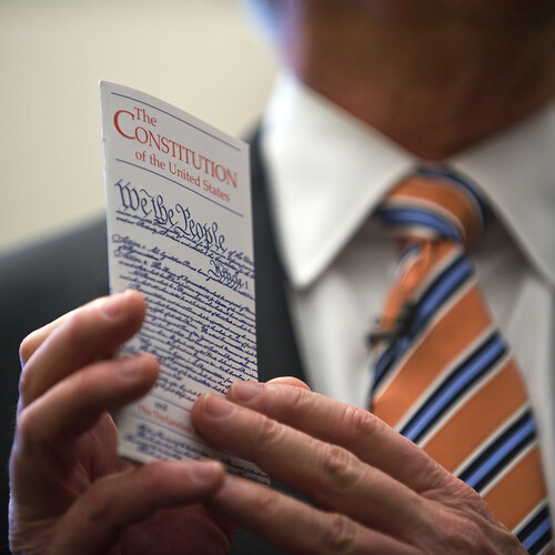 A person holding a pocket Constitution.